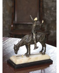 2033-Probablemente ESCUELA FRANCESA, pp. s. XX. Don Quijote" Figura criselefantina sobre peana en ónix representando a Don Quijote sobre su caballo Rocinante. Algún desperfecto. Medidas: 40x1
