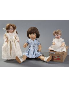 2004-Lote de tres muñecas antiguas, dos de pp. s. XX en porcelana y una tercera años 60. Con sus vestidos originales. Algún deterioro. Longuitud mayor: 64 cm.