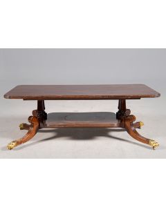 316-Mesa de centro inglesa, s. XIX. En madera tallada con patas terminas en garras en bronce dorado. Sobre ruedas.  Medidas: 44x60x120 cm.
