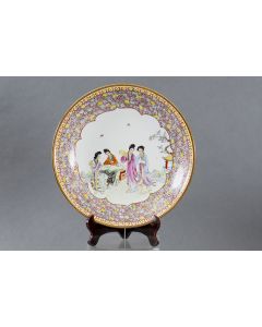 321-Gran plato en porcelana China, c. 1900. Decoración esmaltada de flores en el ala y escena costumbrista en el centro. Diámetro: 40 cm.
