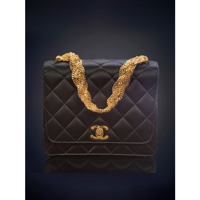 757 TIMELESS CHANEL Bolso de mano en seda negra diseno acolchado en rombos y cierre con las iniciales de la firma en dorado. Bella cadena renzada. Caja y estuche originales. Fernando Duran
