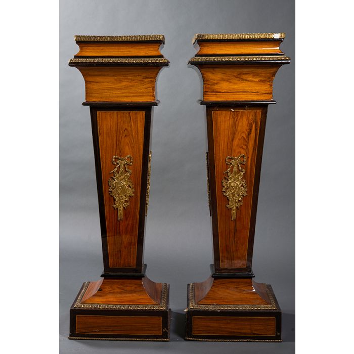 672-Pareja de elegantes peanas estilo neoclásico. En madera tallada y  ebonizada con aplicaciones de bronce dorado. Alguna falta. Medidas:  117x38x38 cm.