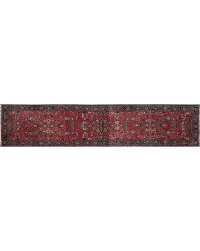 816-Gran alfombra oriental de pasillo  en lana. con decoración vegetal sobre campo rojo.