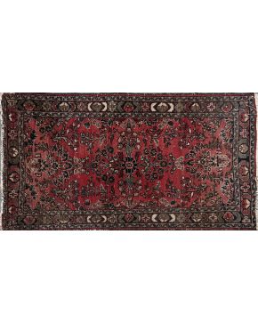 961-Lote de tres pequeñas alfombras orientales en lana y seda. Una sobre campo color teja y motivos geométricos y las otras dos sobre campo granate con mo