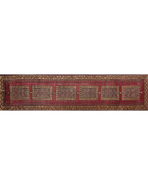 352-Alfombra oriental de pasillo en lana con decoración geométrica de motivos cuadrangulares sobre campo granate. 