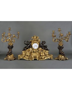 1165-Importante reloj de chimenea. Napoleón III. en bronce dorado al mercurio y pavonado. RAINGO FRÉRES y H. PICARD. con guarnición de candelabros. Francia