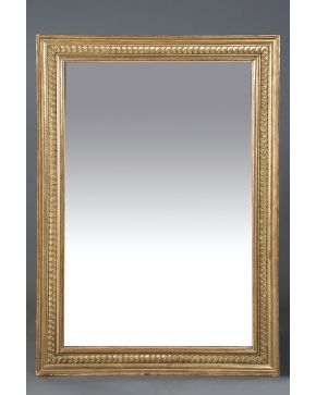 1086-Espejo rectangular con marco clásico en madera tallada y dorada con cenefa decorativa.