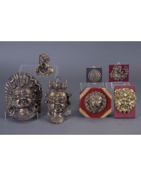 930-Lote en bronce dorado formado por dos antiguas máscaras orientales y un pequeño león japonés del siglo XIX.