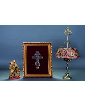 1144-Lámpara de mesa estilo renacimiento en broce con motivos heráldicos y arquitectónicos y fondo en seda roja.