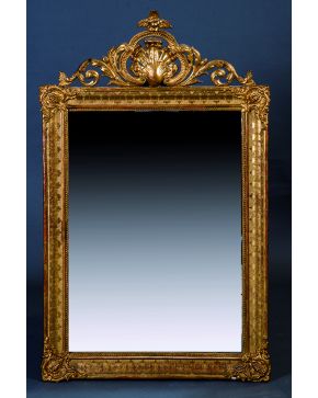 783-Espejo en madera tallada y dorada con decoración de elementos vegetales e importante copete calado. S. XIX