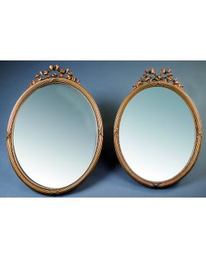 761-Pareja de espejos ovales estilo Luis XVI con marco en madera tallada y dorada con copete en forma de lazada.