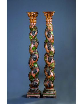 1155-Pareja de columnas salomónicas en madera tallada y policromada con motivos eucarísticos de hojas de parra. pámpanos y vides. s. XIX.