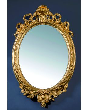 788-Espejo oval dorado estilo Luis XVI con remate vegetal. Con faltas.