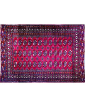 1289-Lote de dos alfombras persas en lana ambas con decoración geométrica de formas circulaes y cenefa perimetral sobre campos granate y marrón respectivam