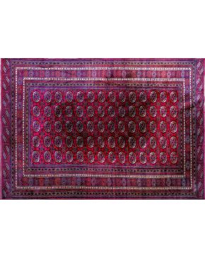 1305-Alfombra persa en lana con diseño geométrico de rosetas sobre campo granate y triple cenefa.