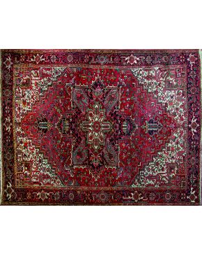 1344-Antigua alfombra persa HERIZ. en lana anudada a mano. Rosetón central polilobulado sobre fondo totalmente cubierto de muestras vegetales y florales es