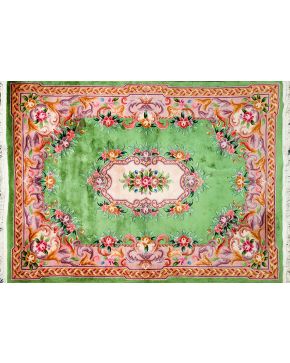1065-Alfombra china en seda y lana con medallón central de flores sobre fondo verde con cenefa en tonos rosas y malvas. Colores complemetarios: marfil y oc