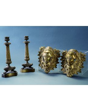 1087-Pareja de candeleros en bronce dorado Napoleón III con fuste estriado y decoración vegetal relevada. terminados en garras. Sobre peana triangular. s. 
