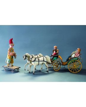 892-Calesa en hojalata pintada con asientos en terciopelo rojo y amarillo. Tirada por dos caballos blancos y portando dos pequeñas muñecas como pasajeros.