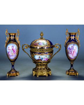 725-Conjunto de guarnición francesa en porcelana polícroma tipo Sèvres con reservas decoradas con escenas galantes y paisajes y fondo azul cobalto. Compue