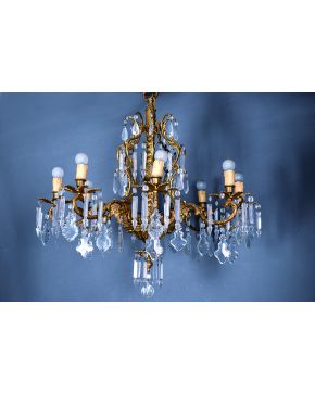 681-Lámpara de techo de ocho luces en bronce dorado y cristal. elagante diseño con elementos vegetales de los que penden prismas y pandelocas. s. XIX.