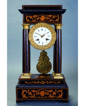 675-Reloj tipo pórtico Napoleón III en madera ebonizada con decoración de marquetería en el frontón y la base. Esfera con firma ilegible en porcelana blan