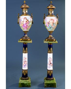 964-Importante juego formado por pareja de jarrones con tapa sobre pedestal en forma de columna en porcelana estilo Sévres con escenas pintadas y firmadas