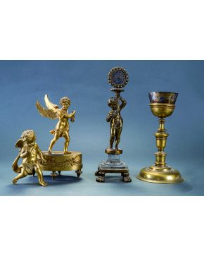 1128-Lote en bronce dorado formado por ángel sobre peana oval con guirnalda de flores y angelito con catalejo. S. XIX.