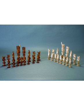 1081-Magnífico ajedrez chino en marfil tallado en su color y teñido en té. Piezas de gran virtuosismo con base circular en forma de mandala y original pede