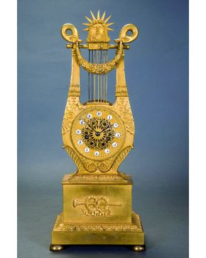 967-Péndulo lira imperio C.1810. en bronce dorado. La esfera en forma de rosetón calado con placas esmaltadas para los números y rematado por una máscara 