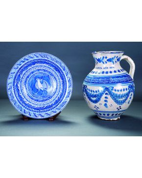1228-Lote formado por jarra en cerámica azul y blanca con decoración de guinaldas. fechada en 1878 y fuente en cerámica esmaltada de Montemayor. Talavera. 