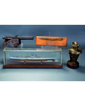 609-Lote de cuatro objetos de coleccionismo naval: cañon de hierro. maqueta de submarino en fanal de cristal. clavo de dique y recipiente en bronce sobre 
