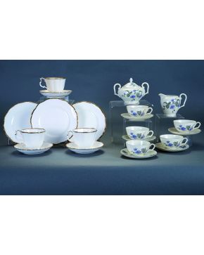 584-Juego de café en porcelana checoslovaca Victoria de fondo blanco con flores en lila. Formado por; 9 tazas. 11 platos. azucarero y lechera.