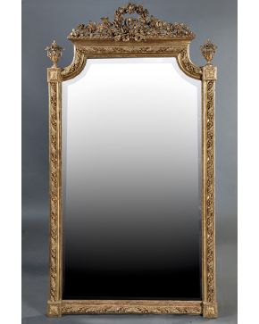 713-Espejo biselado estilo Neoclásico en madera tallada. dorada y policromada con copete vegetal y corona laureada. Remates laterales en forma de jarrón y
