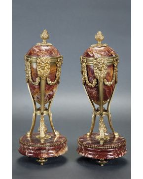 910-Casolettes franceses estilo Imperio en mármol rosa con aplicaciones en bronce en forma de guirnaldas y mascarones. Remate en forma de piña y patas de 