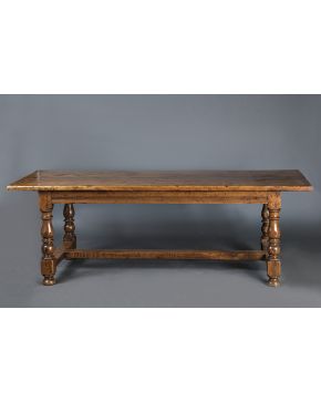 543-Gran mesa española de refectorio antigua en madera tallada de nogal. Patas torneadas unidas por gran chambrana.