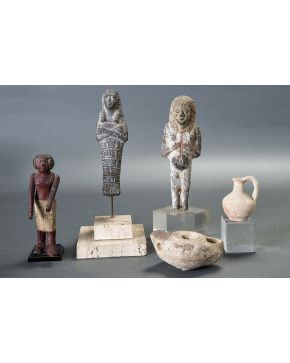 1113-Lote de cinco figuras arqueológicas: lucerna romana en terracota s. I-III d. C.; oinochoe en terracota romano s. II-III d. C.; ushebty egipcio en pied
