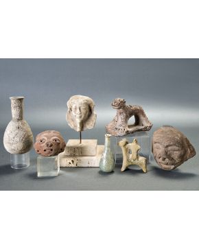 1114-Lote de 7 piezas arqueológicas: dos caritas precolombinas en terracota; dos lagrimales romanos en vidrio; una máscara egipcia en terracota; una figura