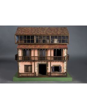 413-Casa de muñecas en madera tallada y pintada. S. XX. Galería y balcones exteriores. Tres plantas y mobiliario variado con accesorios.