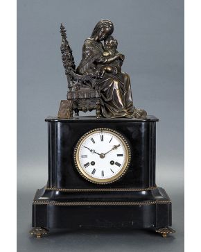 999-Reloj de sobremesa Napoleón III en mármol negro con figura en bulto redondo de maternidad en bronce pavonado de remate. siglo XIX. Esfera en porcelana