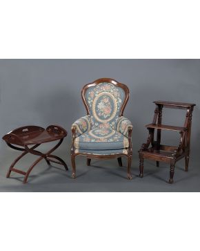 308-Sillón siglo XX en madera con respaldo curvo y tapizado en tela azul con flores de tonos rosas y verdes..