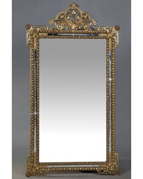 549-Espejo rectangular estilo Rococó en madera tallada y dorada con importante copete calado de elementos vegetales y filo en cristal dorado. 