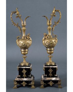 776-Pareja de jarras decorativas frencesas en bronce dorado profusamente labrado y relevado con guinaldas y elementos vegetales. dispuestas sobre pedestal