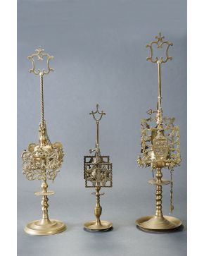 480-Lote formado por tres velones de mesa de cuatro luces en bronce dorado con pantallas caladas de motivos herádicos.