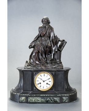 423-Reloj francés en bronce pavonado con figura exenta de filósofo de la antigüedad sobre base de mármol negro. Esfera blanca firmada Raingopres Paris e