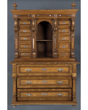 514-Cabinet en madera tallada de cuerpo inferior con tres registros de cajones enmarcados por columnas y cuerpo superior con hornacina central y laterales