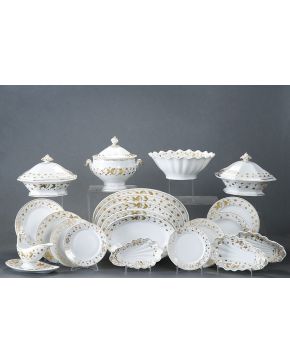 871-Vajilla en porcelana esmaltada blanca. mediados del s. XX. con cenefa de flores dorada en el ala. Formada por: 26 platos llanos. 15 platos hondos. 6 p