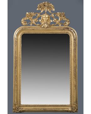 703-Espejo con marco italiano en madera tallada y dorada. S. XIX con gran copete vegetal calado con mascarón central y decoración de flores. Algún desperf