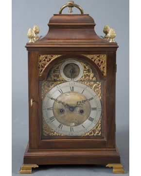 466-Reloj bracket inglés con caja en madera y pletina en latón dorado de perfil recortado. Esfera firmada Ralp Gout London. con numeración romana en negro