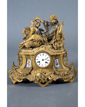 420-Reloj francés de sobremesa en bronce dorado con aplicaciones en porcelana esmaltada con decoración de flores S.XIX. Remate de figura femenina oriental